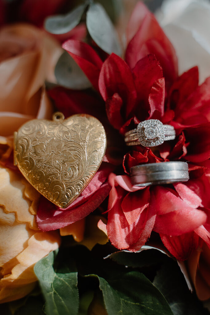 detail photo of rings and locket on a bouquet