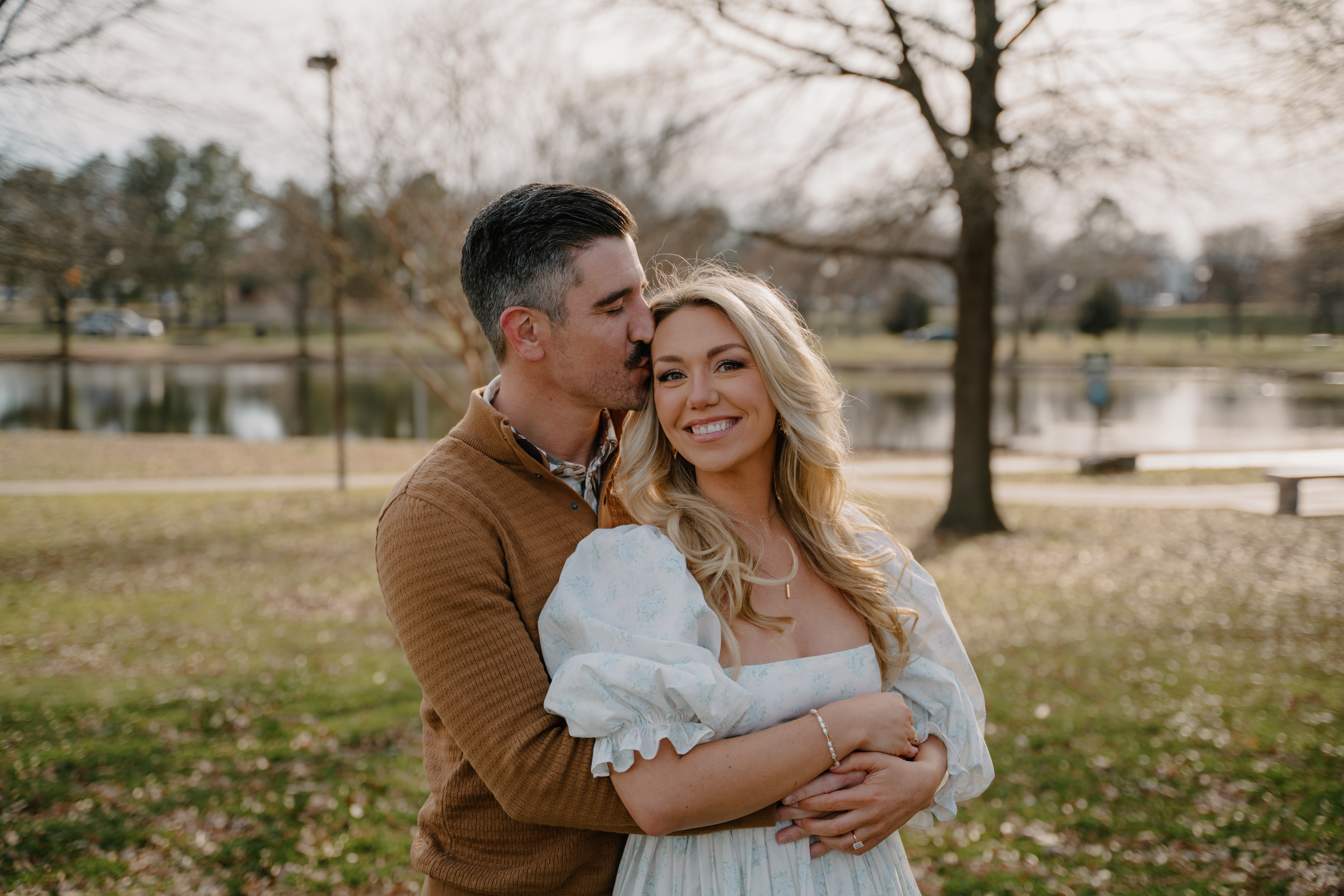 Photo of couple posing in front of a pond at MacArthur Park in Little Rock, Arkansas for their engagement photos