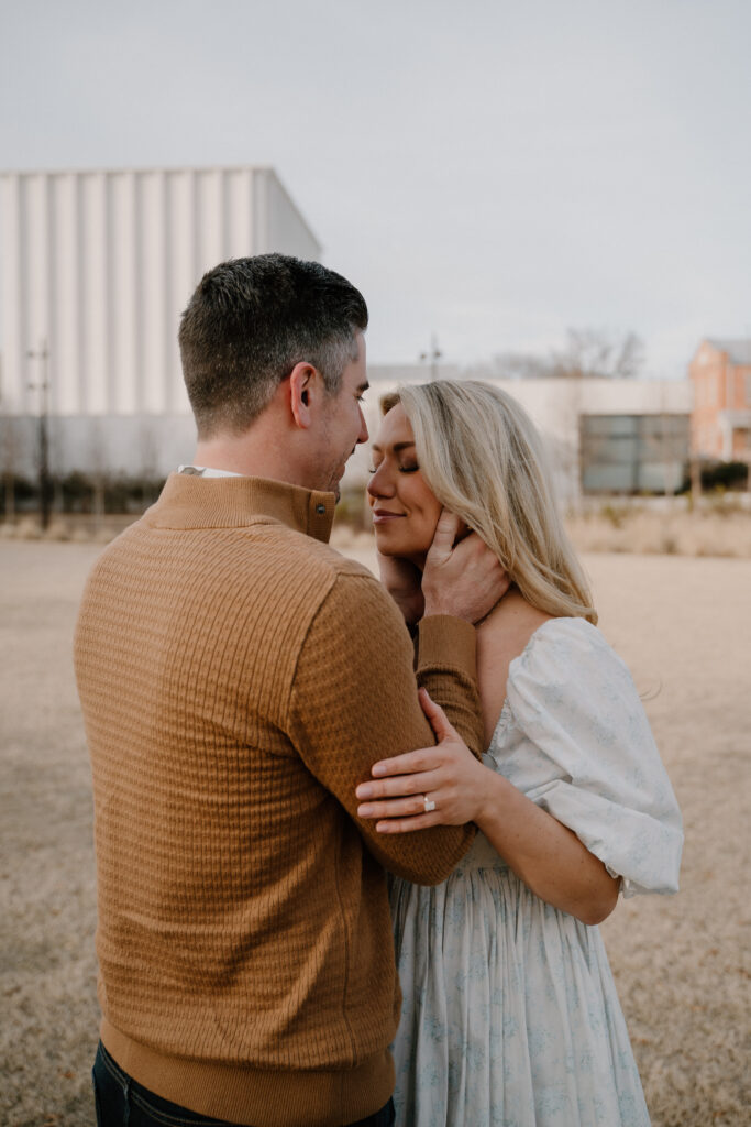 photo of engaged couple posing behind the Arkansas Museum of Fine Art in Little Rock