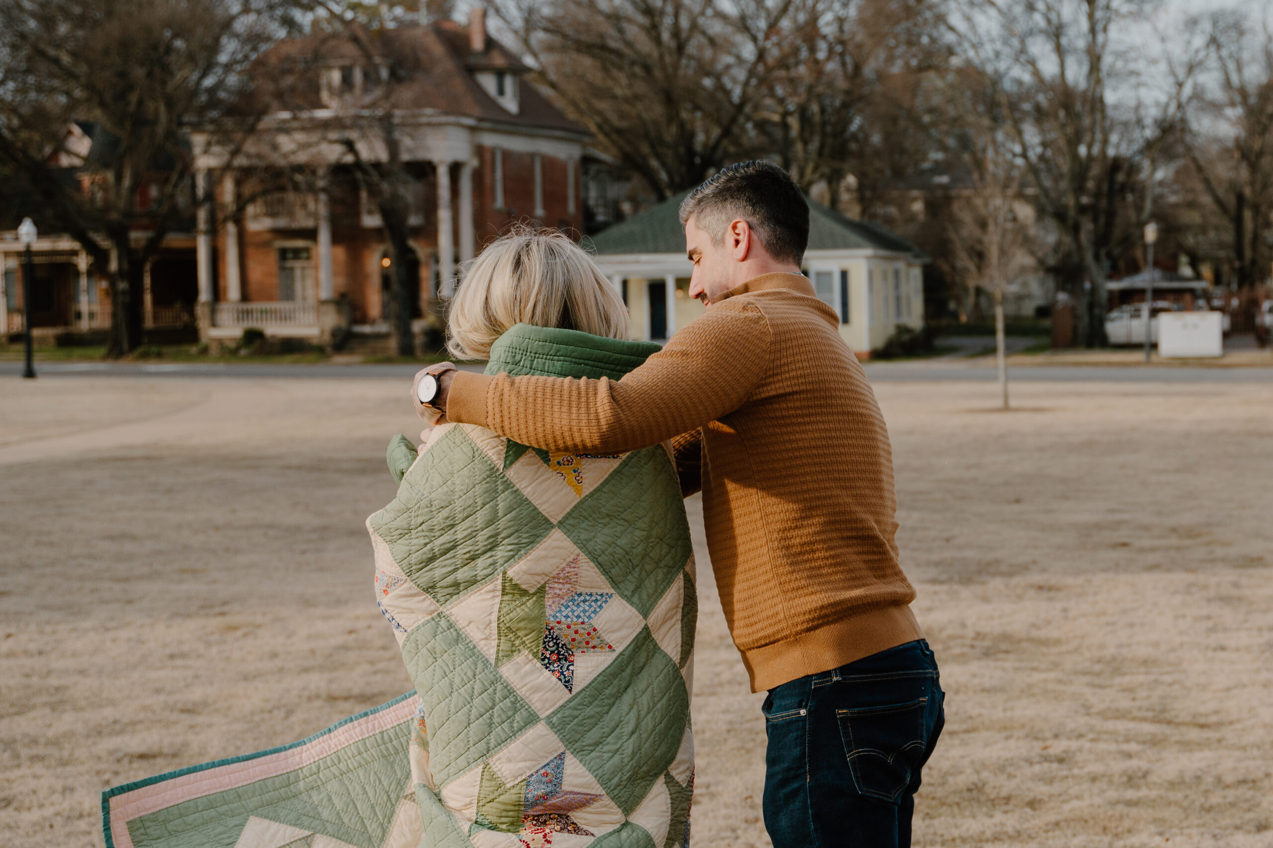 photo of man wrapping up cold woman in a blanket