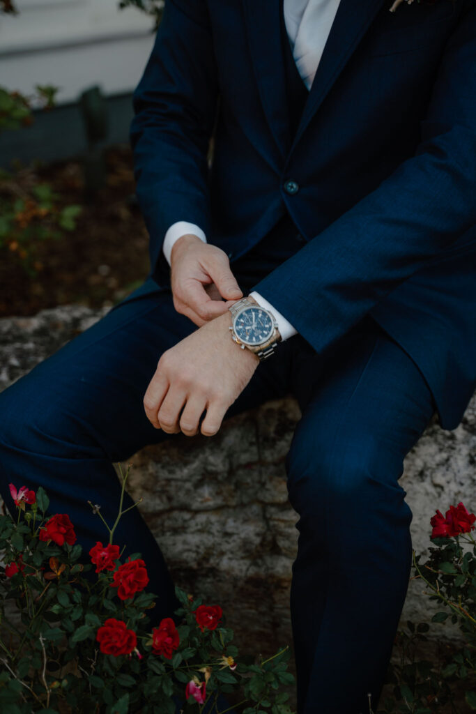 photo of groom posing messing with his watch