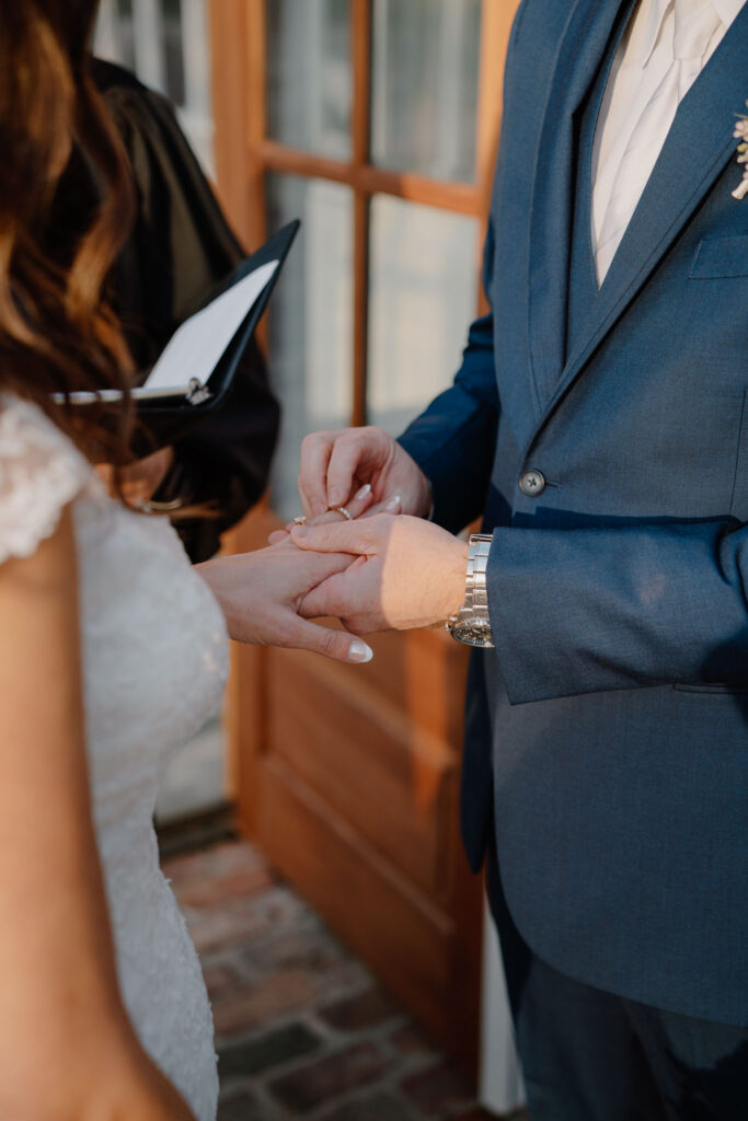 photo of groom putting on bride's ring
