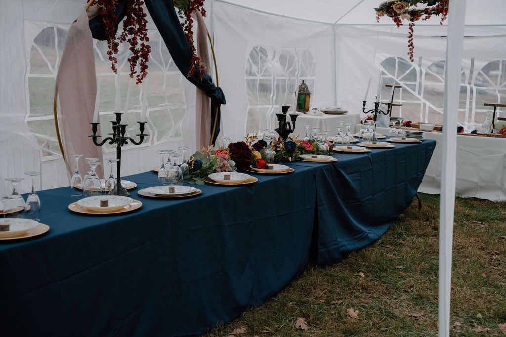 Photo of wedding tablescape and decorations outside in a tent