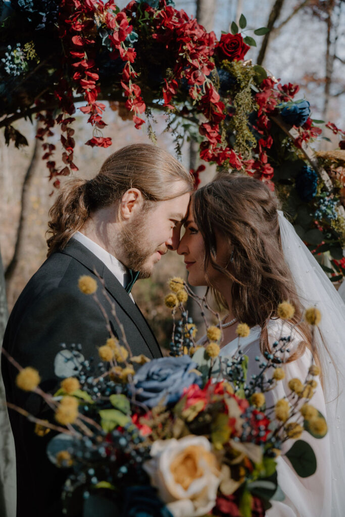 photo of bride and groom with their heads together with florals all around