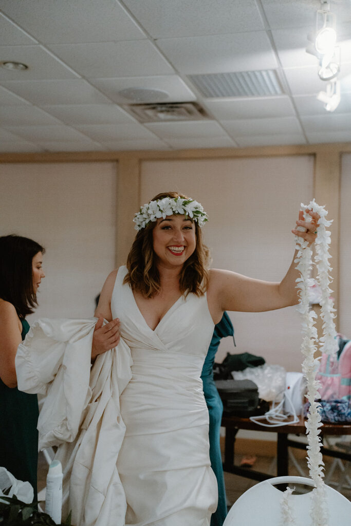 Photo of bride holding up the lei her groom is to wear