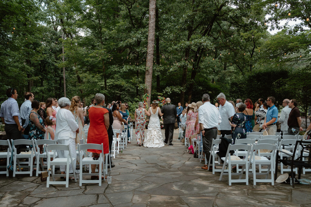 wide angle photo of bride being walked down the aisle by her parents