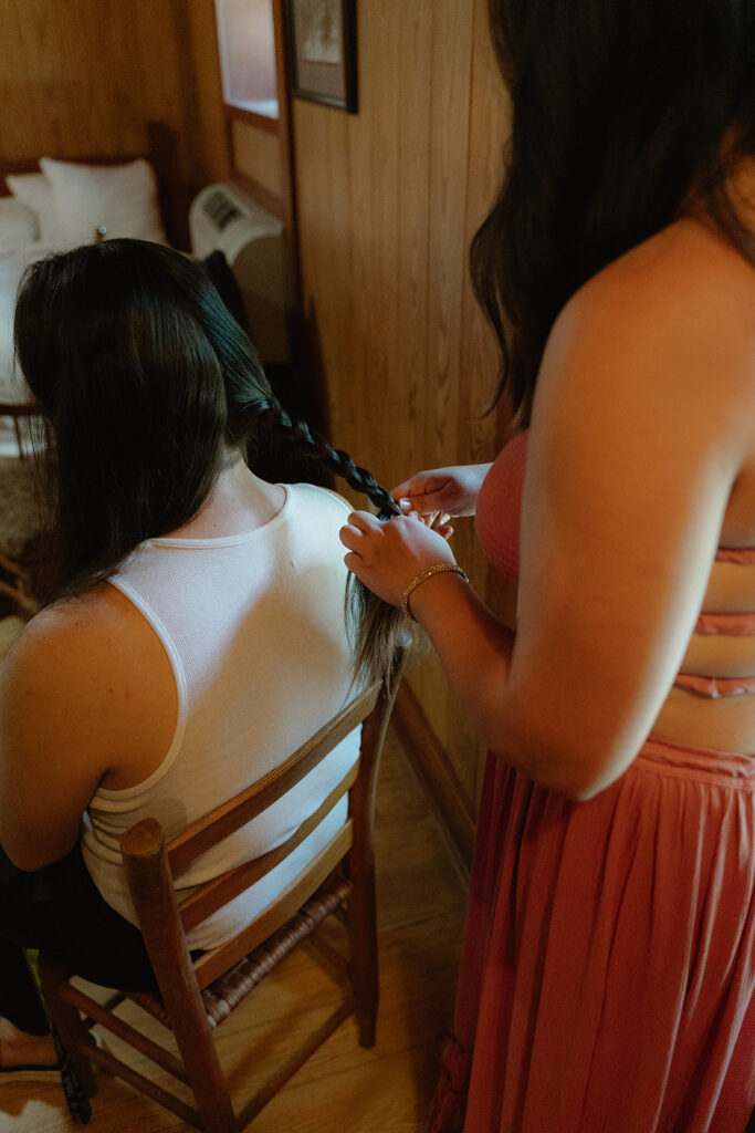 photo of groom's sister braiding his hair