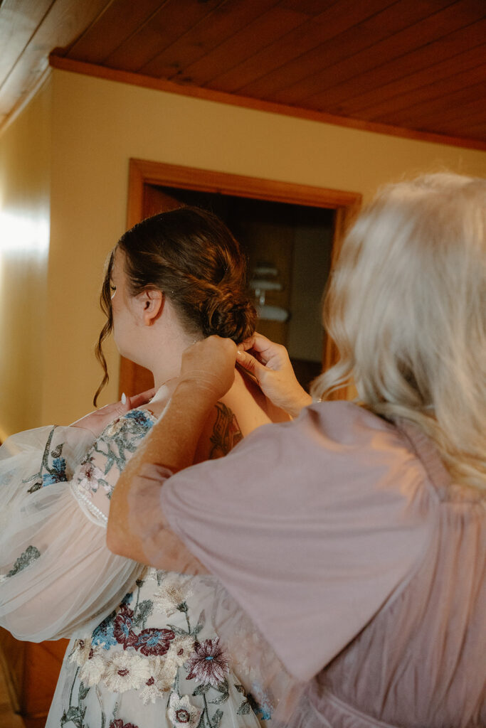 photo of mother of the bride helping the bride get ready