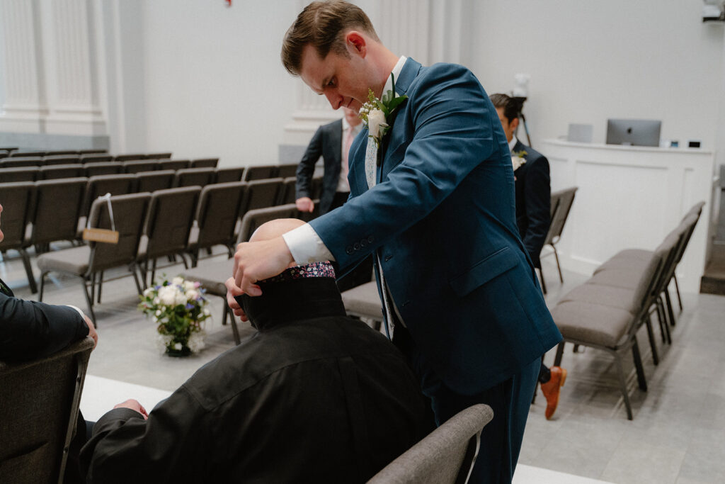 photo of groom putting father's tie on