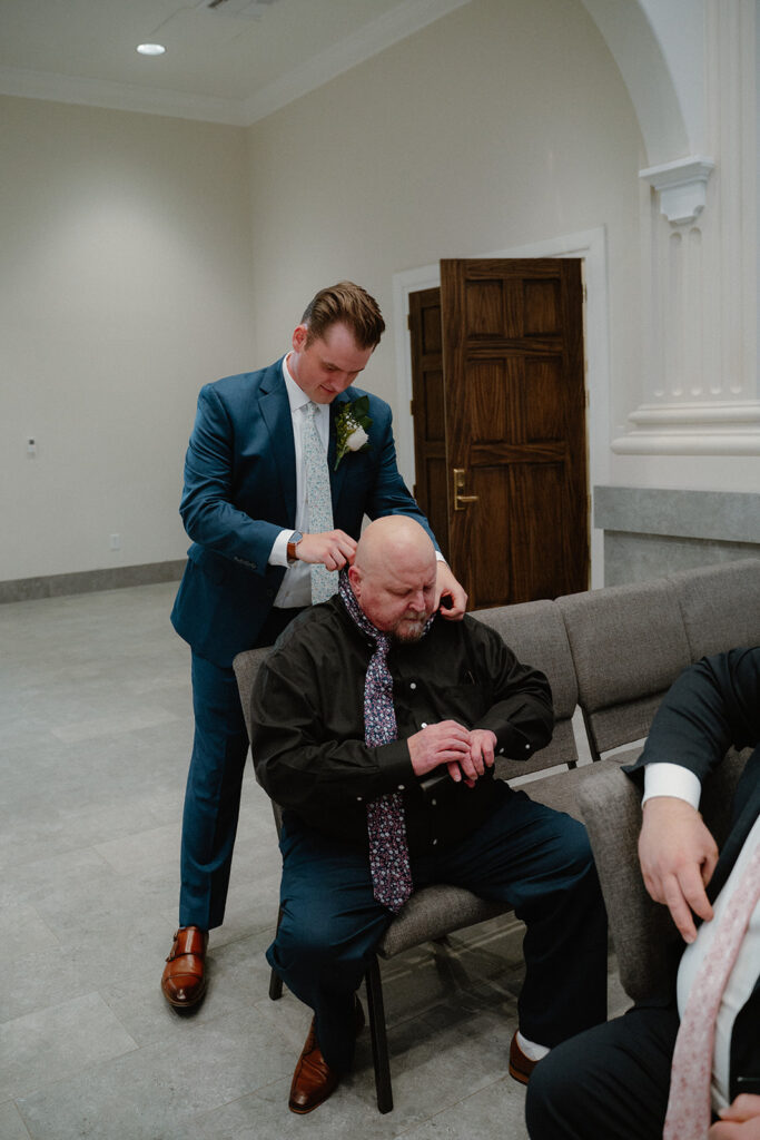 photo of groom putting father's tie on