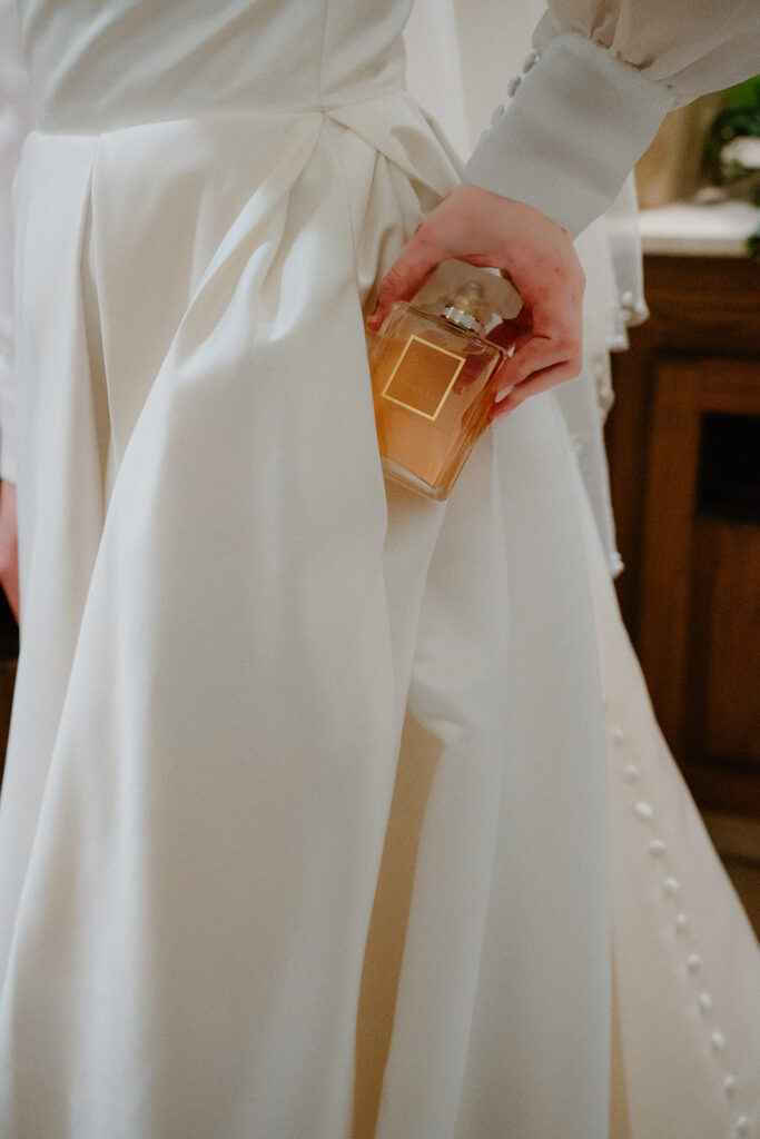 photo of bride putting perfume in her pocket