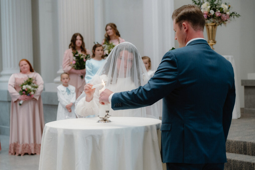 photo of bride and groom lighting a unity candle at their wedding