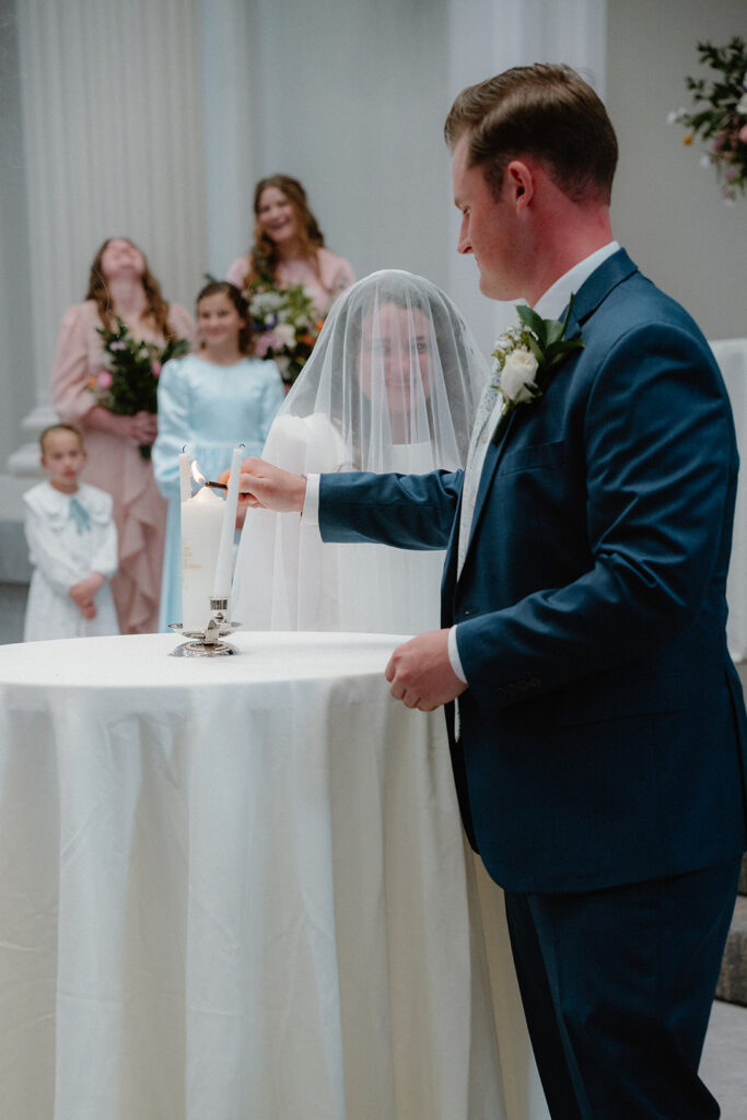 photo of bride and groom lighting a unity candle at their wedding