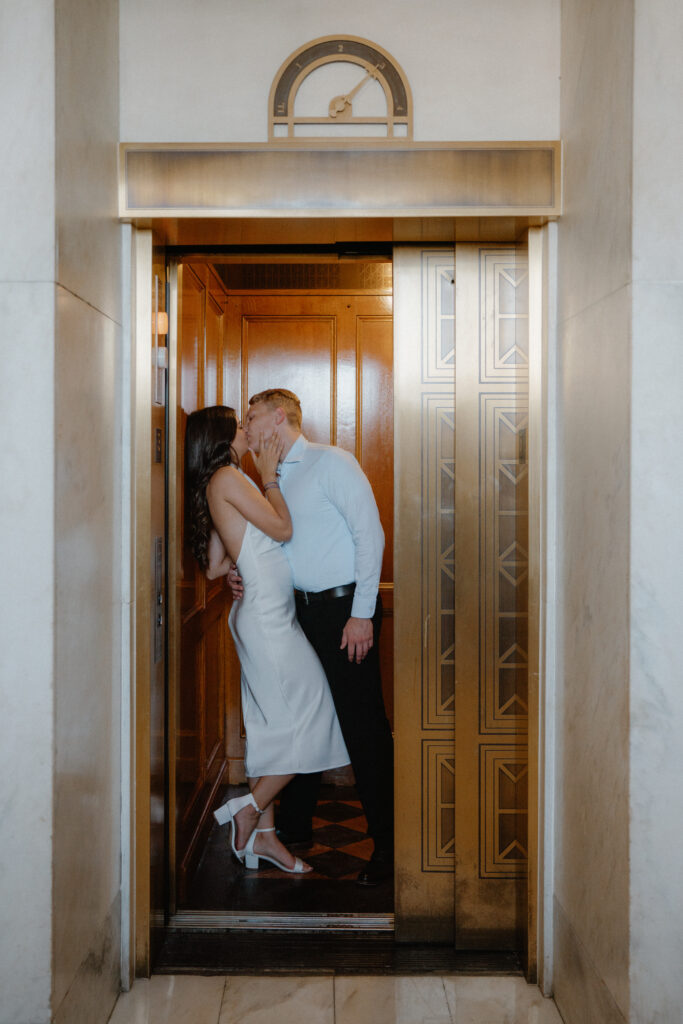 Couple kissing in a gold elevator while the door closes