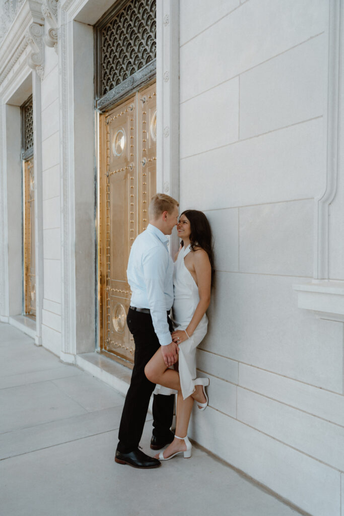 Photo of a couple leaning against a wall of the Arkansas State Capitol during their engagement session
