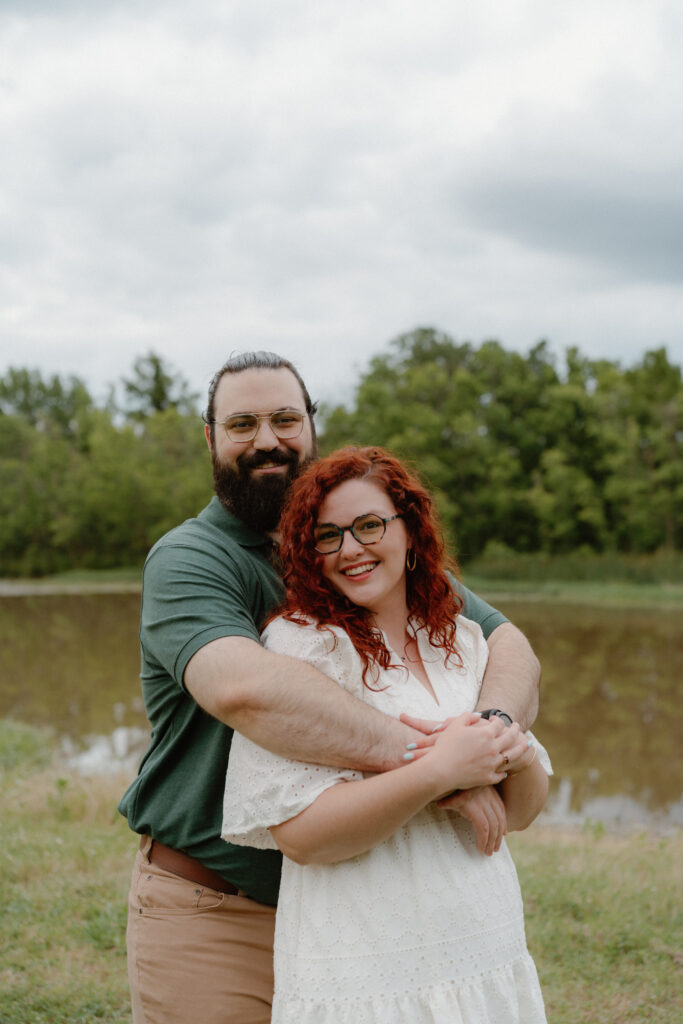 Engagement session at Two Rivers Park with man hugging woman from behind