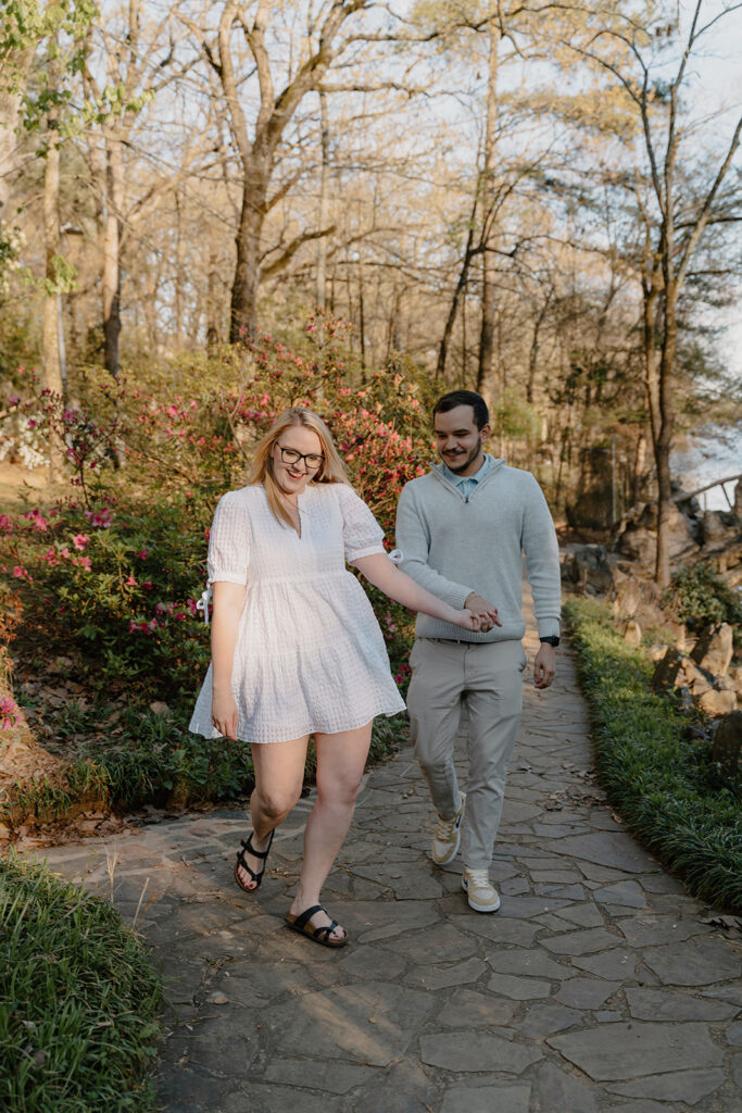 photo of engaged couple walking on a path