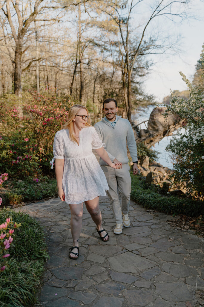 photo of engaged couple walking on a path