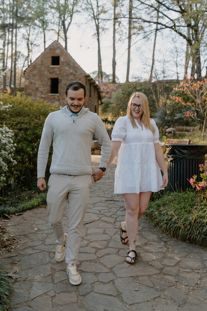 photo of engaged couple walking on a path