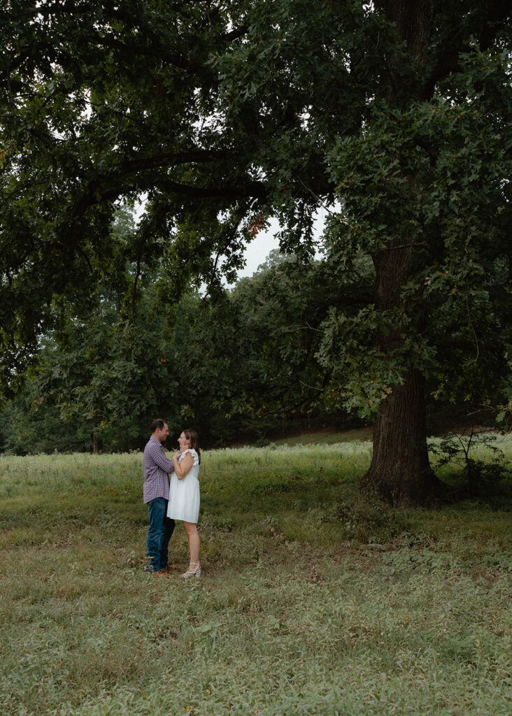 photo of engaged couple under a tree