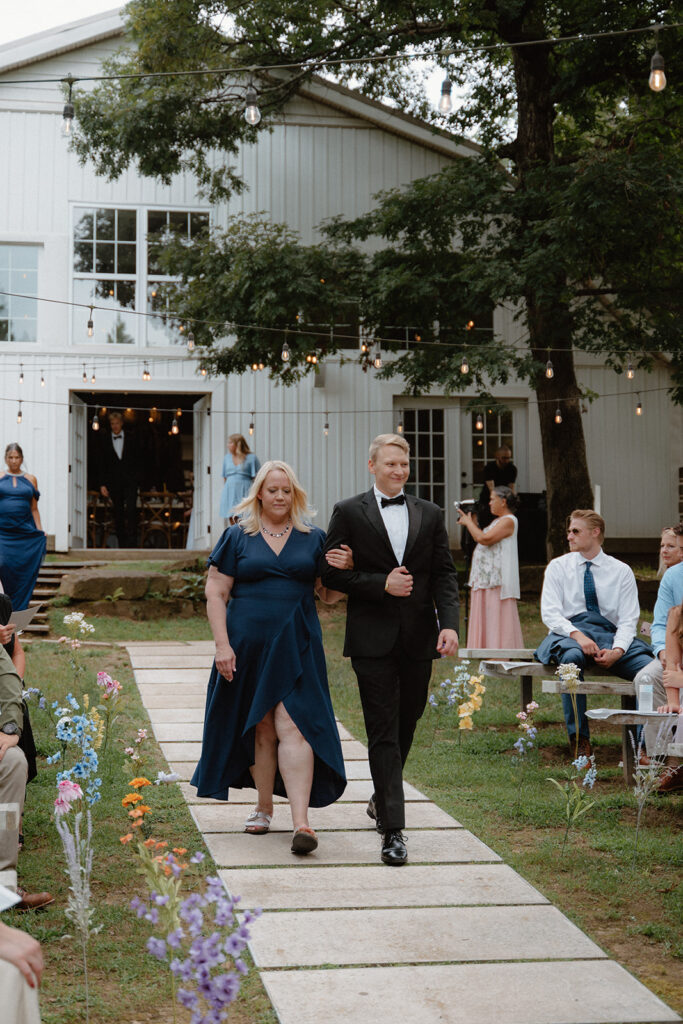 photo of groom and his mom walking down the aisle before he gets married in Arkansas